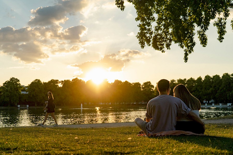 Auf der Wiese vor dem Biergarten lässt sich der Sonnenuntergang über dem Aachener Weiher besonders gut genießen | Die Kölner Parkweiher – Aachener Weiher